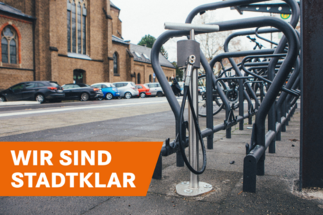 Eine überdachte Radstation mit Fahrradständern und einer Luftpumpe